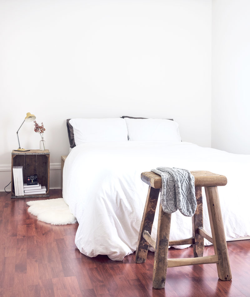 Freshly made bed in a clean, bright bedroom