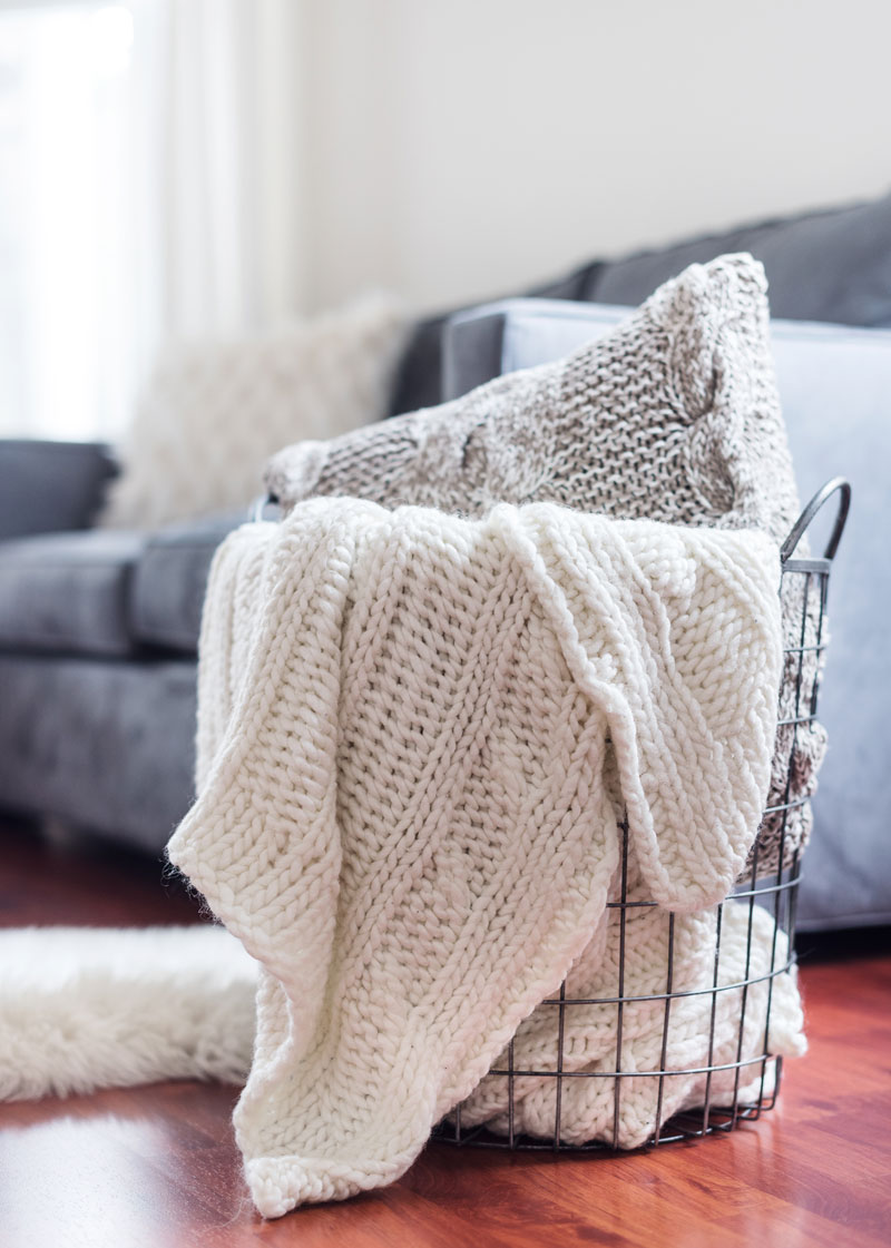 Neatly arranged sofa with a folded knit throw