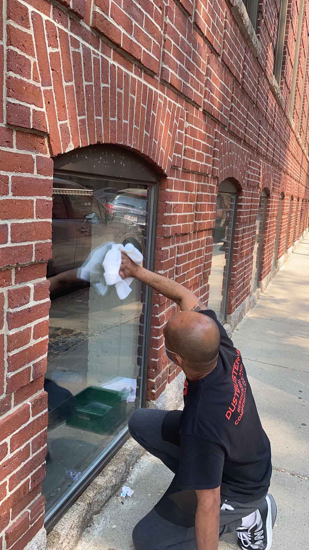 Dustbusters team member cleaning a window by hand