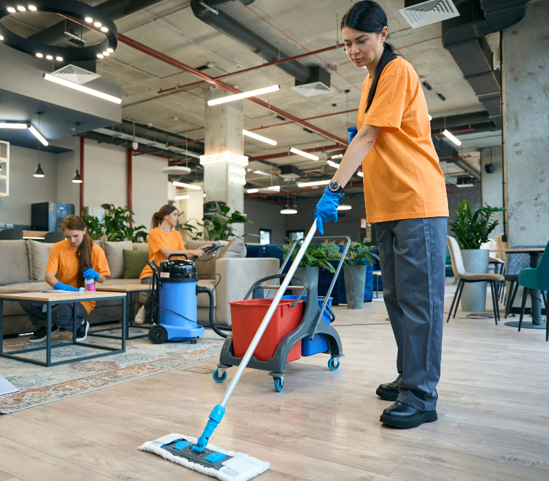 Cleaner mopping the floor of an open office lounge area